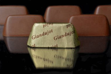 İtalyan gıda ürünü, Gianduiotto geleneksel Piedmont çikolatası ve fındıklı siyah arka plan..