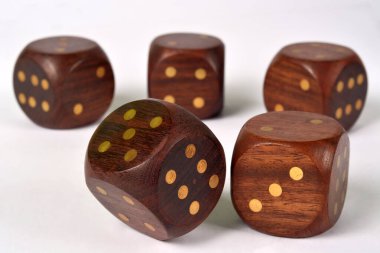 Beyaz arka planda beş büyük tahta zar grubu.