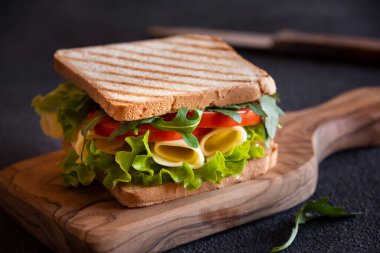 Delicious sandwich with toasted bread, lettuce, cheese and tomatoes. clipart