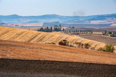 Tractor working on farming lands, countryside landscape