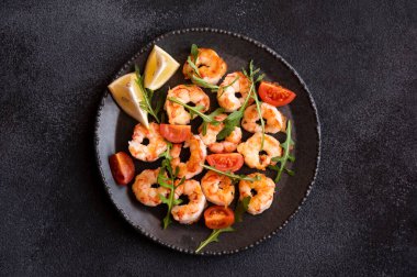 Delisicous cooked shrimps with tomatoes and lemon