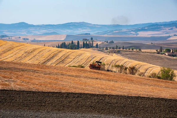 Tractor working on farming lands, countryside landscape