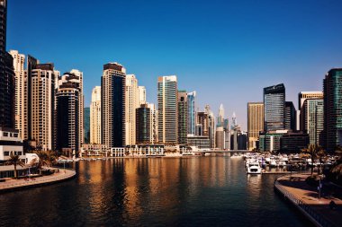 Dubai marinası, sudan görünen gökdelenleri olan modern bir şehir.