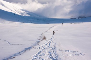 Kış manzarası, güneşli bir günde kar vadisinde ayak izleri.