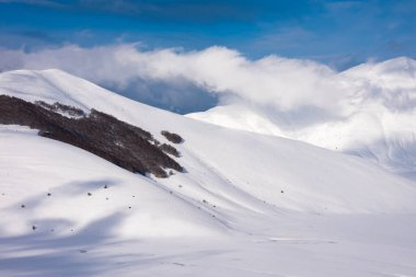 Kış manzarası, vadi ve tepeler güneşli bir günde karla kaplı.