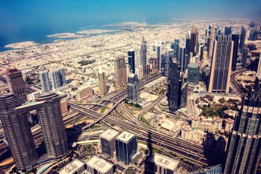 Günbatımında Dubai gökdelenleri sudan görünen modern şehir.