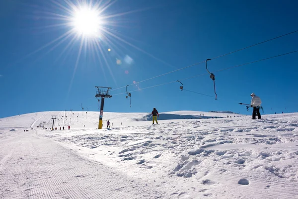 在阳光明媚的冬日 人们在我的度假胜地乘坐滑雪车 — 图库照片