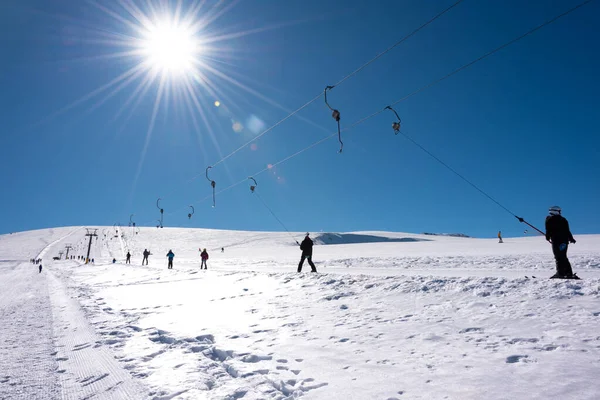 在阳光明媚的冬日 人们在我的度假胜地乘坐滑雪车 — 图库照片