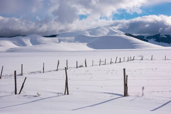 stock image Winter landscape, wooden fence in snow valley on sunny day