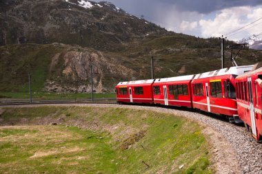Kızıl tren İsviçre 'de güzel bir arazide ilerliyor.