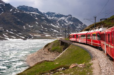 Kızıl tren İsviçre 'de güzel bir arazide ilerliyor.