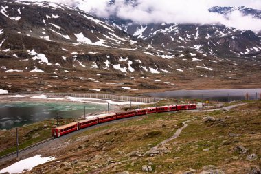 Kızıl tren İsviçre 'de güzel bir arazide ilerliyor.