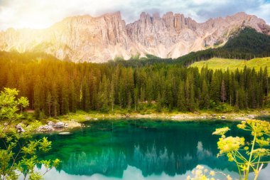 Carezza Gölü Dolomite Alplerinde orman ve dağlarla çevrilidir.