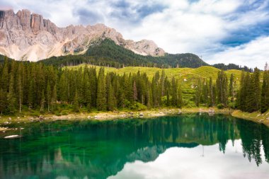 Carezza Gölü Dolomite Alplerinde orman ve dağlarla çevrilidir.