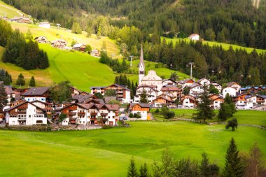 Dolomite Alpleri 'nde bir kilisesi olan dağ köyü Yazın yeşil çayırlarda