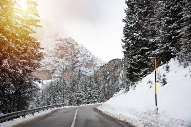 İtalya 'daki Dolomite dağlarında ormanların arasında kış yolu