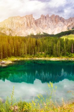 Carezza Gölü Dolomite Alplerinde orman ve dağlarla çevrilidir.