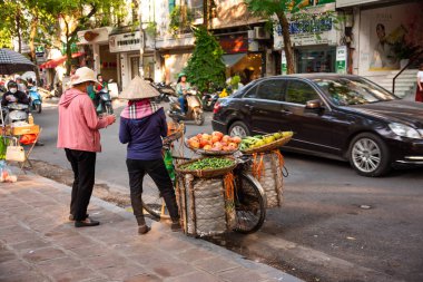 Geleneksel Vietnam şapkalı kadın Hanoi sokaklarında bisikletle meyve satıyor.,