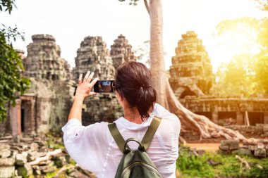Kadın turist Kamboçya 'daki Angkor tapınağının fotoğrafını çekiyor.