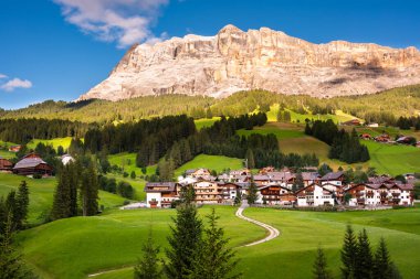 Dolomite Alpleri 'nde bir kilisesi olan dağ köyü Yazın yeşil çayırlarda