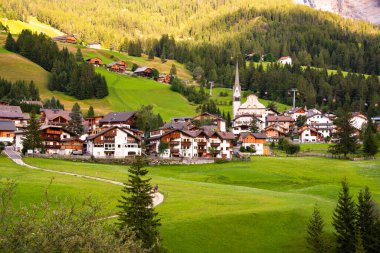 Dolomite Alpleri 'nde bir kilisesi olan dağ köyü Yazın yeşil çayırlarda