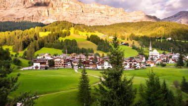 Dolomite Alpleri 'nde bir kilisesi olan dağ köyü Yazın yeşil çayırlarda