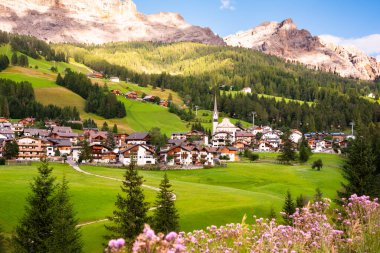 Dolomite Alpleri 'nde bir kilisesi olan dağ köyü Yazın yeşil çayırlarda
