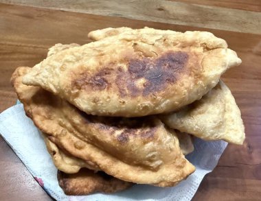 Atıştırmalık çizelgeler. Et fotoğrafçılığı yapan börekler. Kırsal arkaplanda üst görünüm.