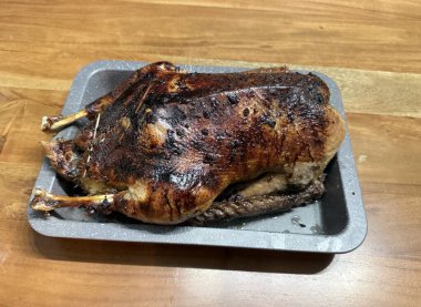 Tepside servis edilen kızarmış tavuk. Fırın pişmiş tavuk ve tahta üzerinde et çatalı..