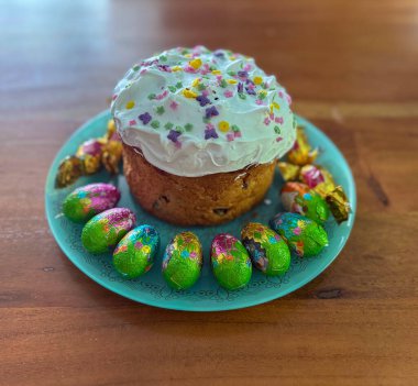 Classic Easter ham dinner. Top view table scene on a white background. Ham, eggs, hot cross buns, carrot, cake and vegetables.