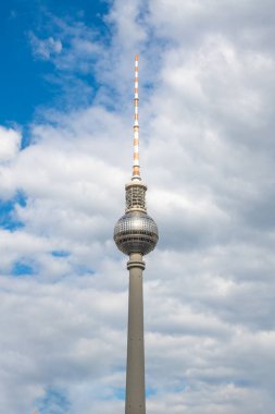 Berlin TV kulesi içinde bir restoran ve radyo antenleri olan küre beyaz bulutlarla kaplı bir gökyüzüne karşı.