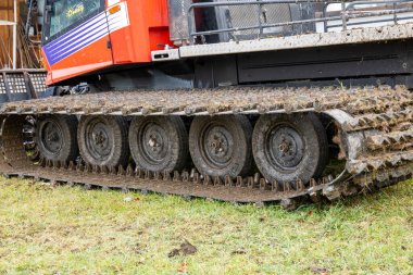 Lochheim, Bayern / Almanya - 23.11.2023: Çok geniş ve toprakla kaplı bir kar tımarcısı sürüş zinciri. Zincirlerin genişliğini ve zincirin içindeki tekerlekleri görebilirsiniz..