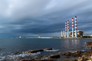 Martigues 'deki Fransız doğalgazla çalışan elektrik santralinin ve artık kullanılmayan dört eski bacasının görüntüsü. Arka planda tehditkar bulutlar görülebilir