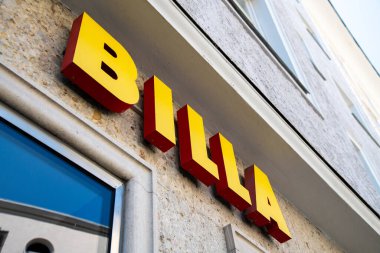 Salzburg, Salzburg - Avusturya 06-17-2021: Bir ev cephesinde Billa süpermarket zincirinin sarı harfleri. Aşağıda, bir dükkan penceresi görebilirsiniz..