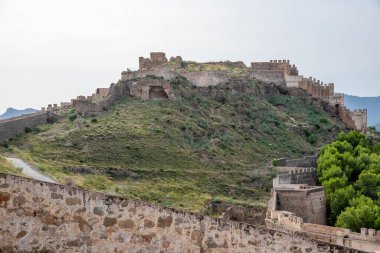 Sagunt, Valencia - İspanya - 09-07-2021: Sagunt Kalesi harabelerinin geniş görüşü. Açıkça görünen yapılar, duvarlar ve yollar. Kalenin içi bitki örtüsüyle kaplı..