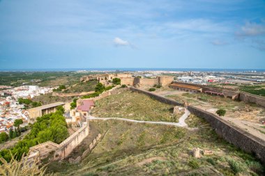 Sagunt, Valencia - İspanya - 09-07-2021: Sagunt Kalesi 'nin harabelerine geniş bir bakış açısı. Binalar, duvarlar ve yollar açıkça görülüyor. Kalenin içi bitki örtüsüyle kaplı..