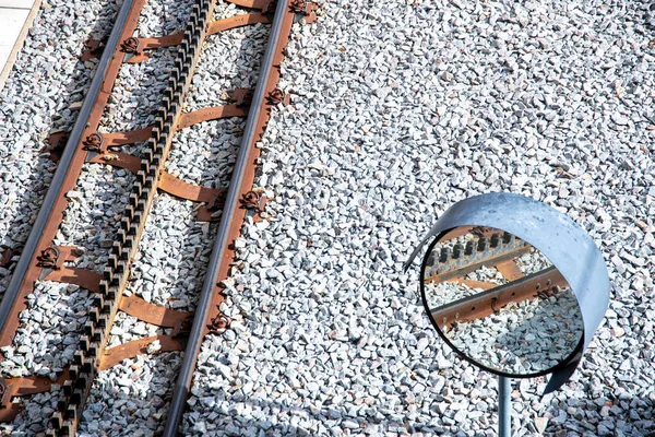 Rail on a shovel bed, which is clearly used. In the middle you can see the slope aid, so that the railway can climb mountains. Next to it is a traffic mirror, in which you can see a part of the rails.