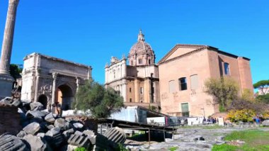 Rom - Latium - İtalya - 11-23-2022: Chiesa Santi Luck e Martina Martiri, zafer kemeri Arco dei Settimio Sever ve Roma 'daki Roma Forumu' ndaki Curia Luia. Resmin sol köşesinde antik binaların parçaları görülebilir.