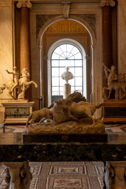 Citta del Vaticano, Vaticano - Stato della Citta del Vaticano - 11-22-2022: Vatikan Müzesi 'nde bir koridor, pencereye dayalı bir heykelle klasik heykeller sergiliyor