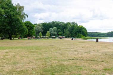 Templin, Brandenburg - Almanya - 06-09-2022: Geniş yeşil alanlar, ağaçlar, plaj alanları ve açık havanın keyfini çıkaran insanlar