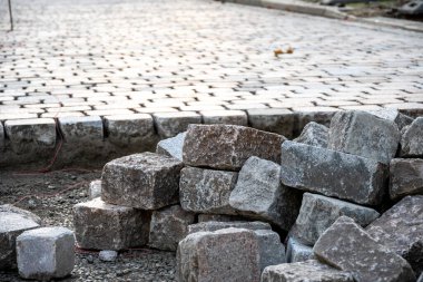 Şehir gelişimini ve altyapı büyümesini sembolize ederek, yol çalışması için düzenlenmiş yeni kaldırım taşları