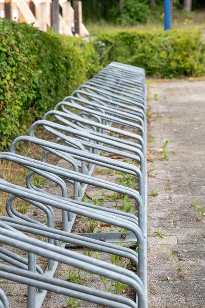 A long, vacant bike rack awaits visitors in a serene park setting
