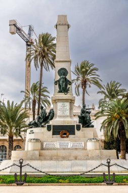 Cartagena, Murcia - İspanya - 01-16-2024: Kartagena 'da savaş anıtı, arkasında bronz heykeller ve yazıtlar, bir vinç ve avuç içi