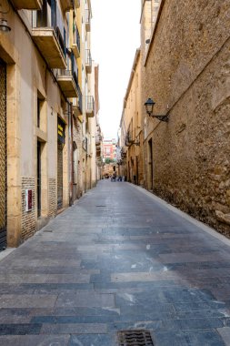 Tarragona, Tarragona- İspanya - 10-31-2023: Oliva, İspanya 'da parlak bir gökyüzü altında eski binalarla çevrili terk edilmiş ara sokaklar