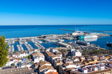 Denia, Alicante - İspanya - 12-22-2023: Denia 'nın limanının feribot, yat ve palmiye çizgili deniz manzaralı panoramik manzarası