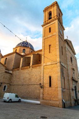 Altea, Alicante - İspanya - 01-05-2024: Altea 'nın kilisesinin belirgin mavi kubbesi ve çan kulesiyle gün batımı manzarası