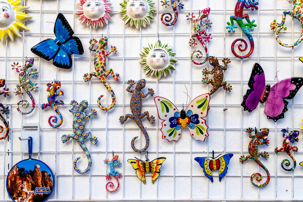 El Castell de Guadalest, Alicante - Spain - 12-27-2023: Vibrant ceramic samples, butterfly, and geckos order a wall in Guadalest, showing showing local art