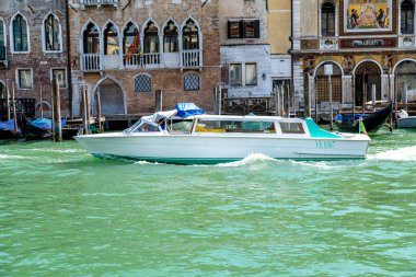 Venedik, Veneto - İtalya - 06-10-2021: Venedik sularında bir sürat teknesi süzülüyor, arka planda klasik Venedik mimarisi ve gondolları var