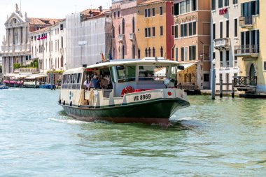 Venedik, Veneto - İtalya - 06-10-2021: Venices Grand Canal boyunca bir Vaporetto su otobüsü gezisi yolcuları tarihi binalar zeminine karşı