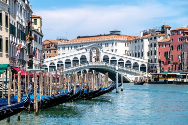 Venedik, Veneto - İtalya - 06-10-2021: Venedik ikonik Rialto Köprüsü, dükkanlarla süslenmiş, hareketli Büyük Kanal boyunca uzanır